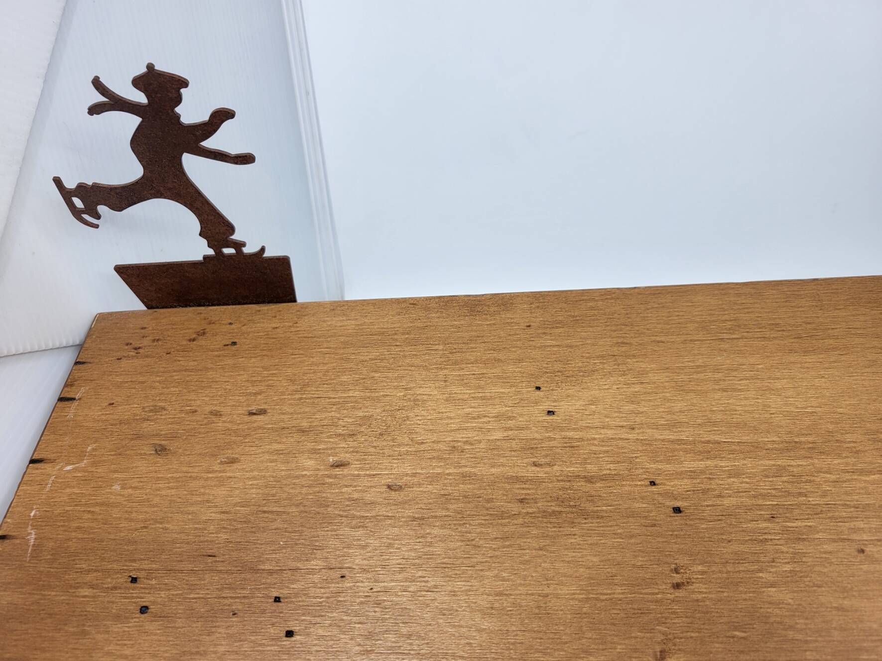 Wall shelf in wood and metal with a decoration of ice skaters.