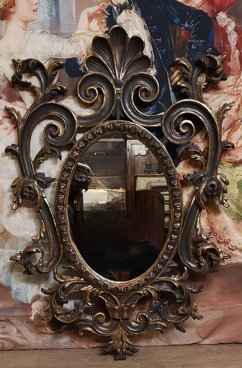 Antique Louis XV style mirror, richly carved with decorations of scrolls, shells, and foliage.