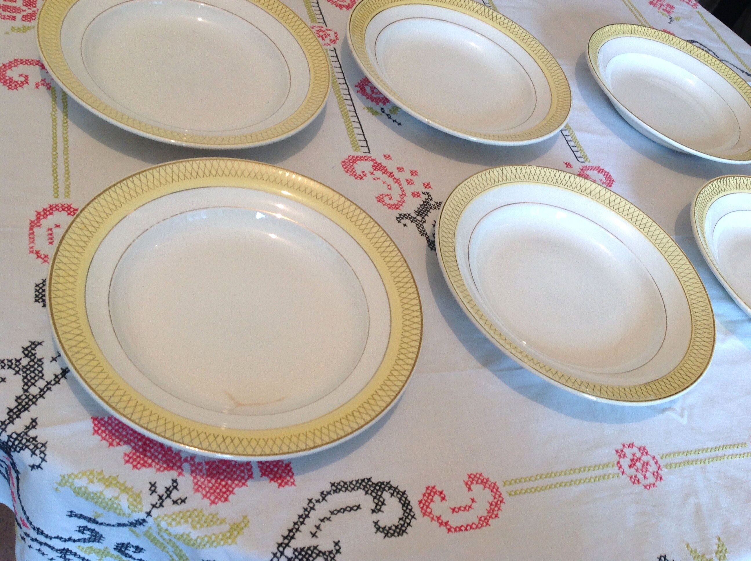 Six white hollow plates on board yellow Monaco 60