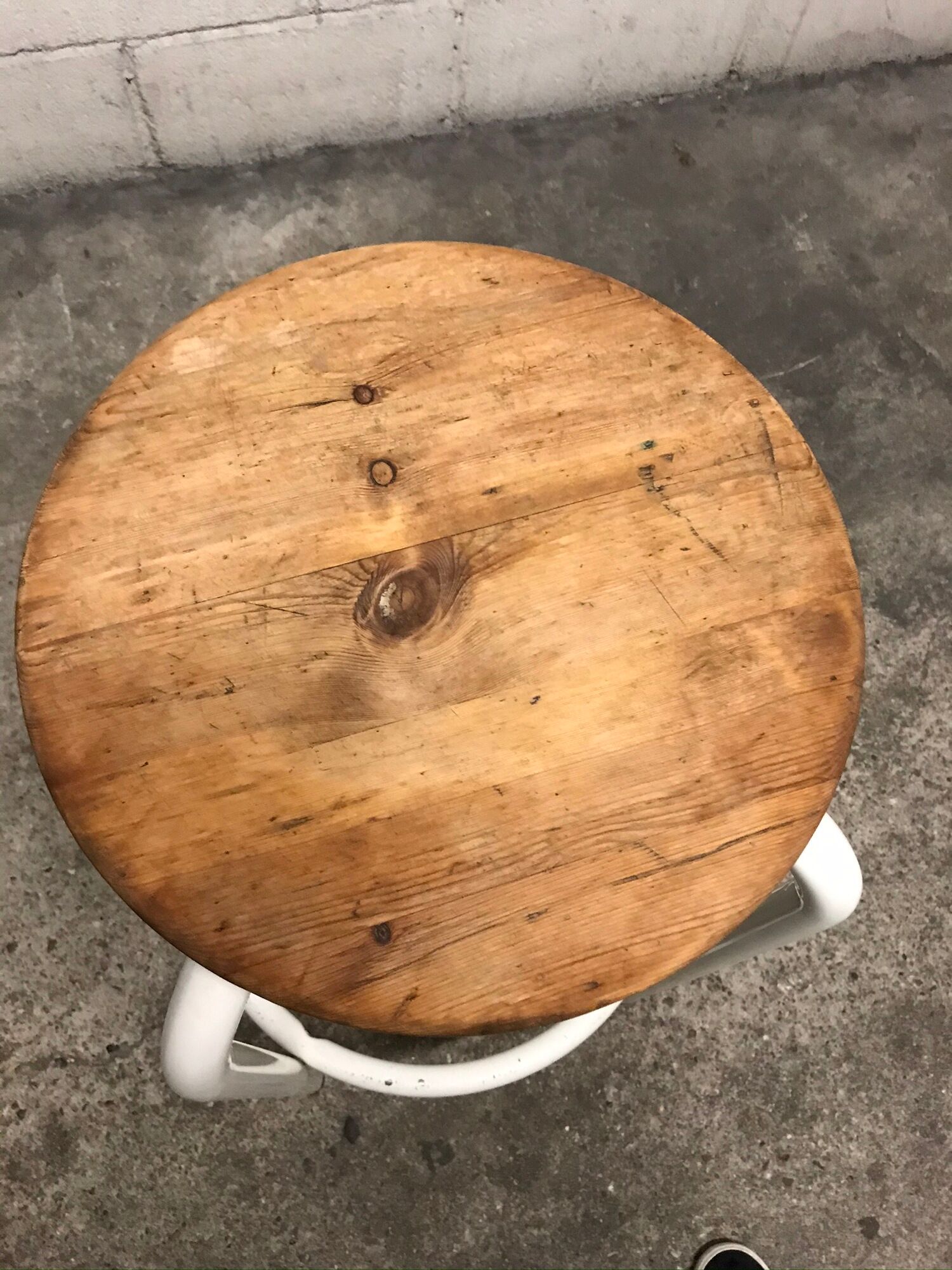 Vintage bar stool in white lace-up, round wooden seat rests circular feet