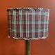 Lamp base in gilded brass, oval silk lampshade with a checkered pattern in burgundy.