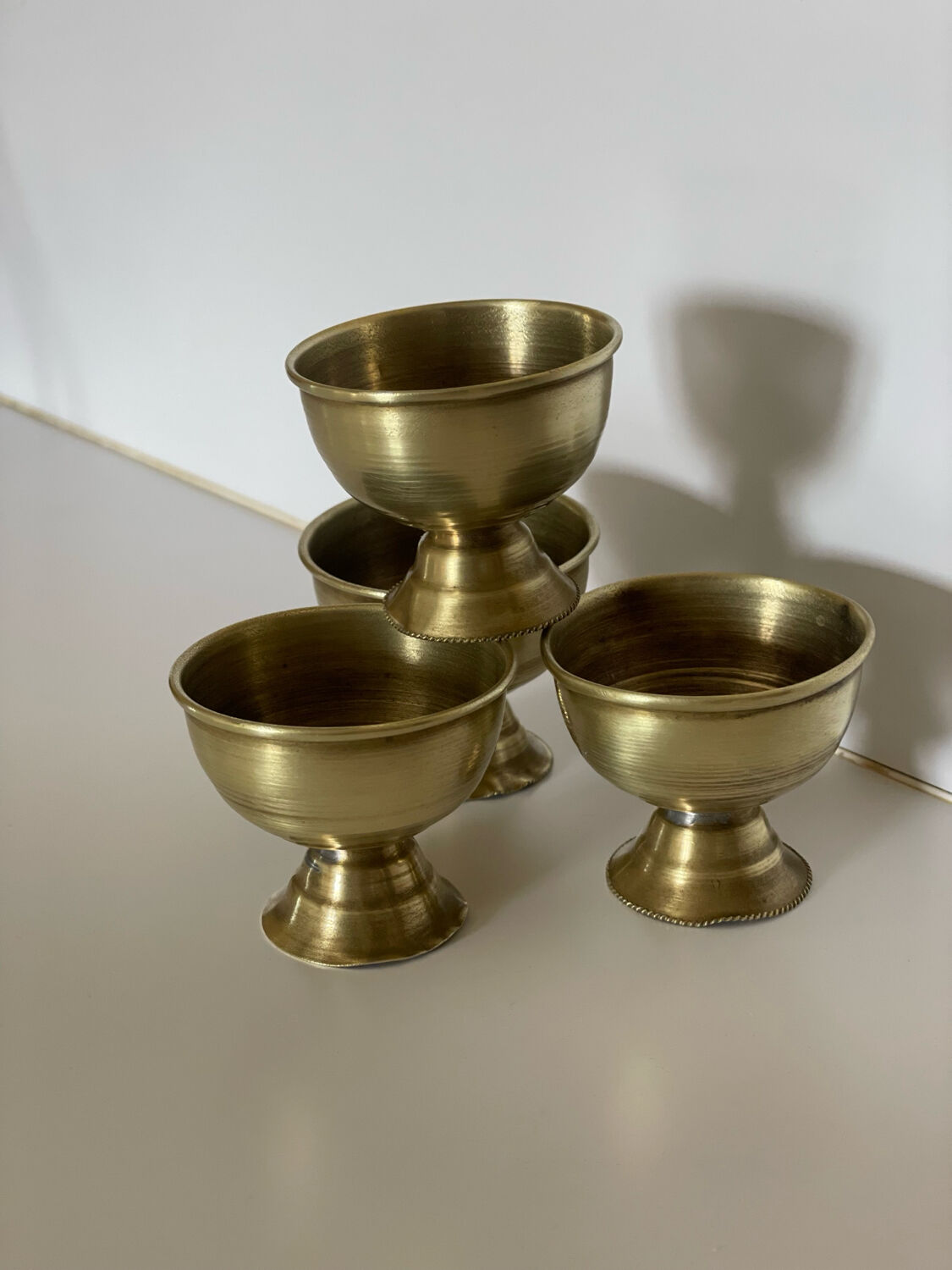4 golden brass egg cups