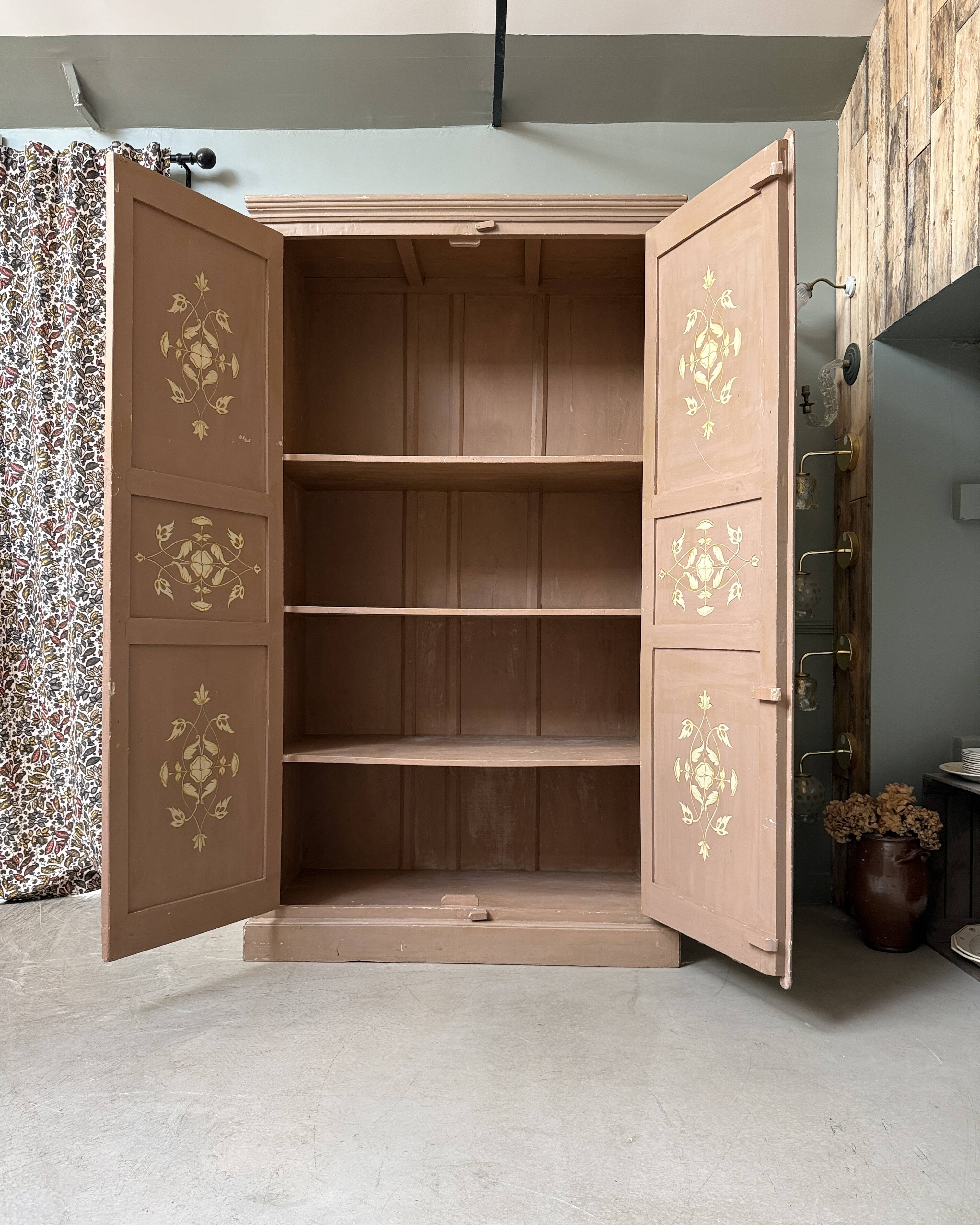 Large antique wardrobe painted with floral decoration.