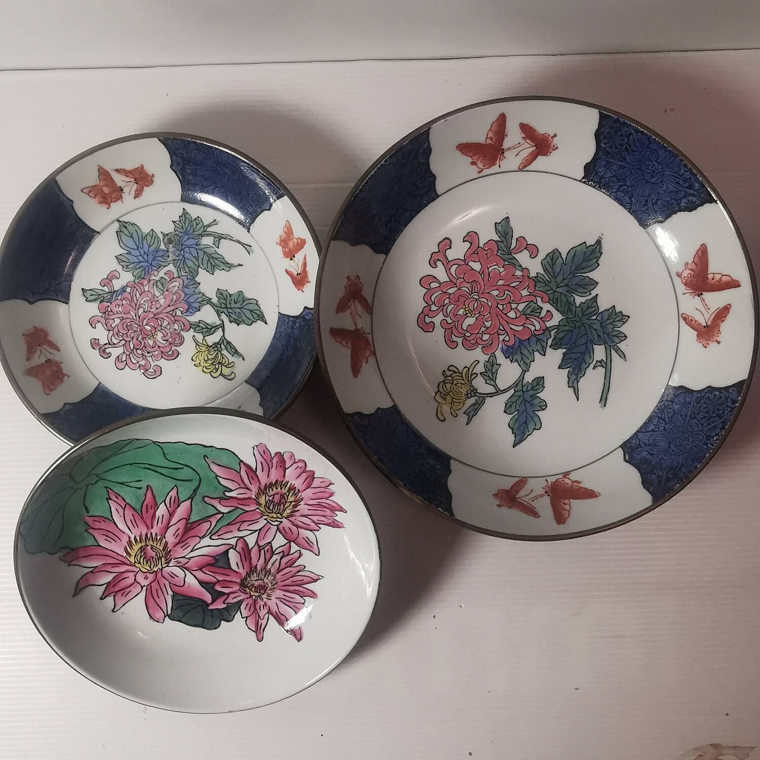 Three decorative plates in Chinese porcelain and brass from the 1960s. signed