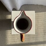 Large antique handmade ochre yellow jug with a pink flower pattern.