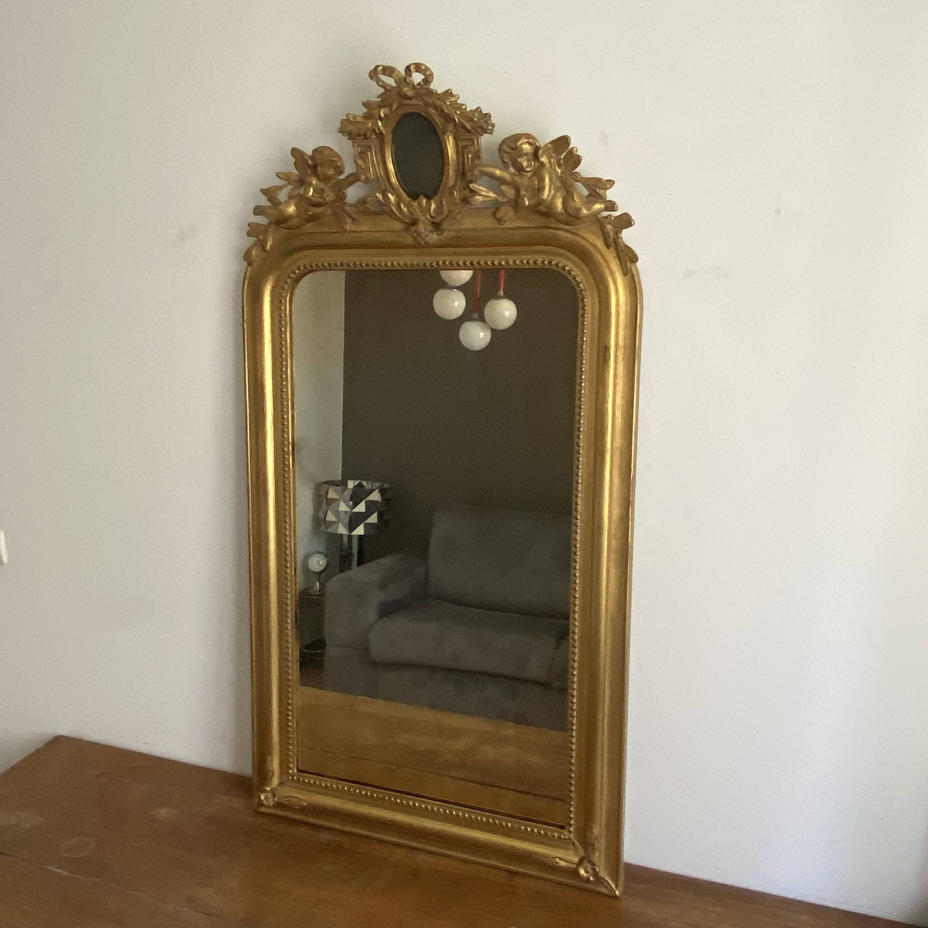 Late 19th century gilded mirror with decorated pediment. 125x70.