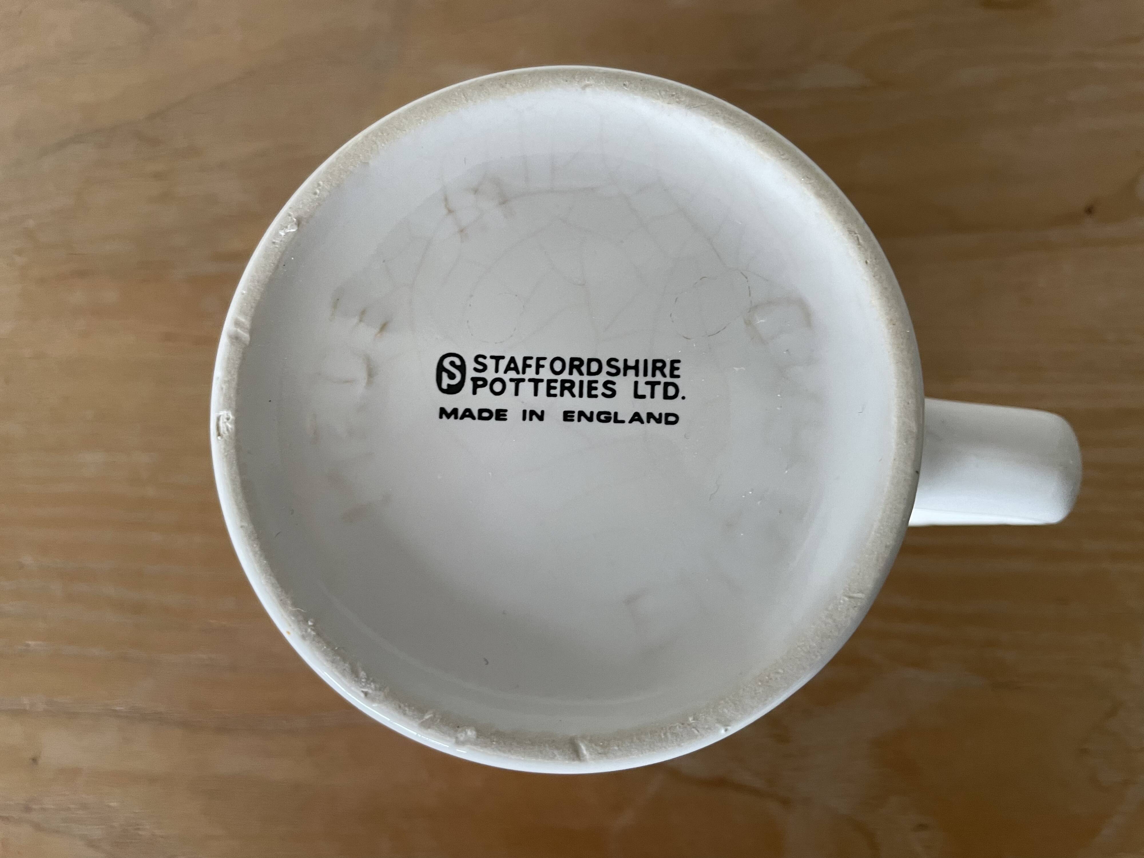 Staffordshire mug made in England with an orange floral motif.
