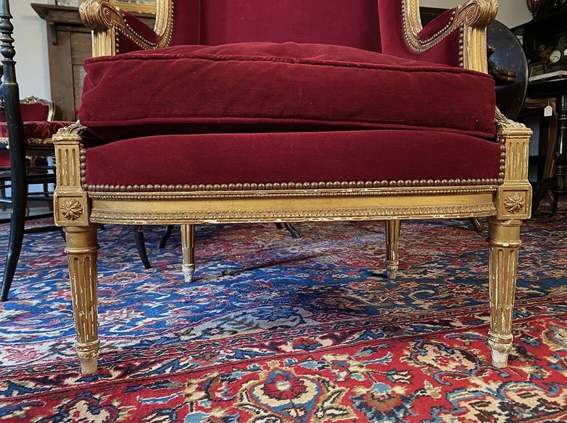 Golden wooden bergère in Louis XVI style upholstered in Bordeaux velvet.