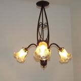 French Art Nouveau leaf detail iron three-light chandelier with amber glass shades.