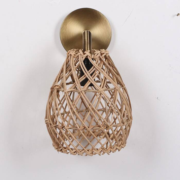 Golden bohemian wall lamp in woven rattan