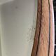 Oval beveled mirror surrounded by light wood dimension: height -74,5cm- width -38,5cm- prof-2cm-