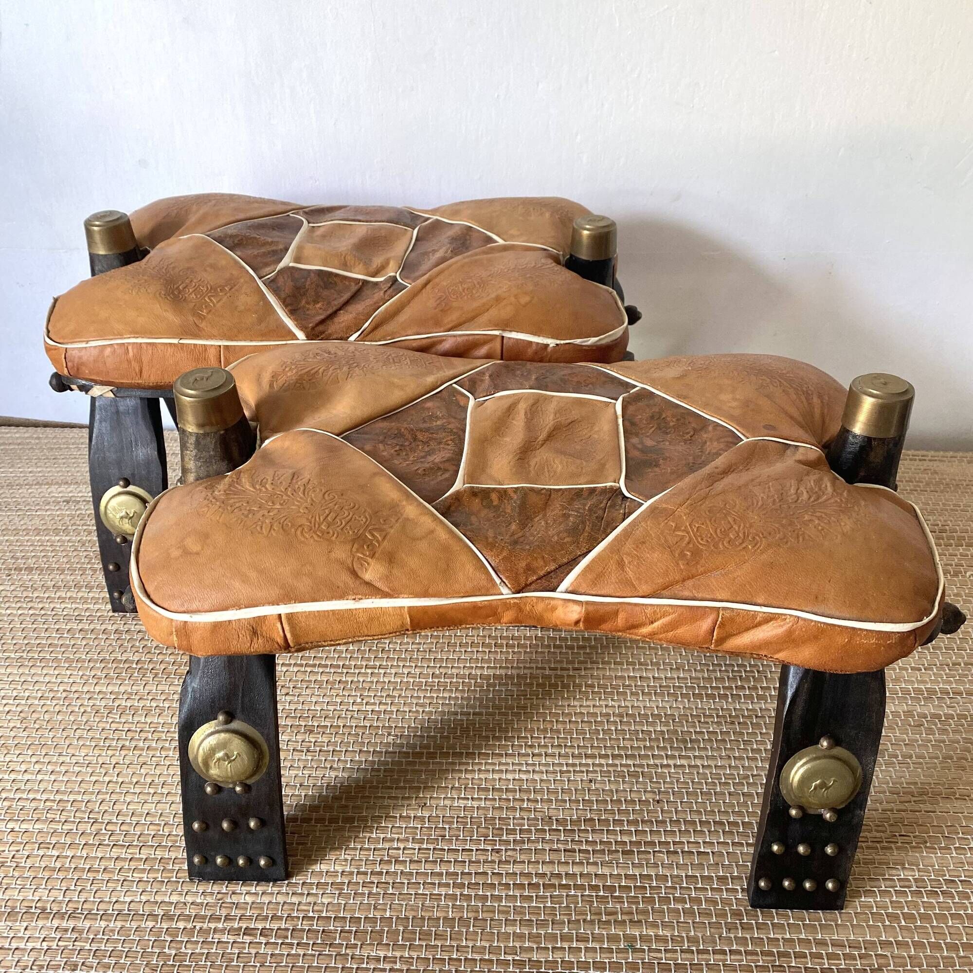 Pair of low Egyptian stools, camel saddles in wood, leather and brass
