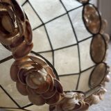 Vintage pendant light with a pearlescent shade and floral decoration.