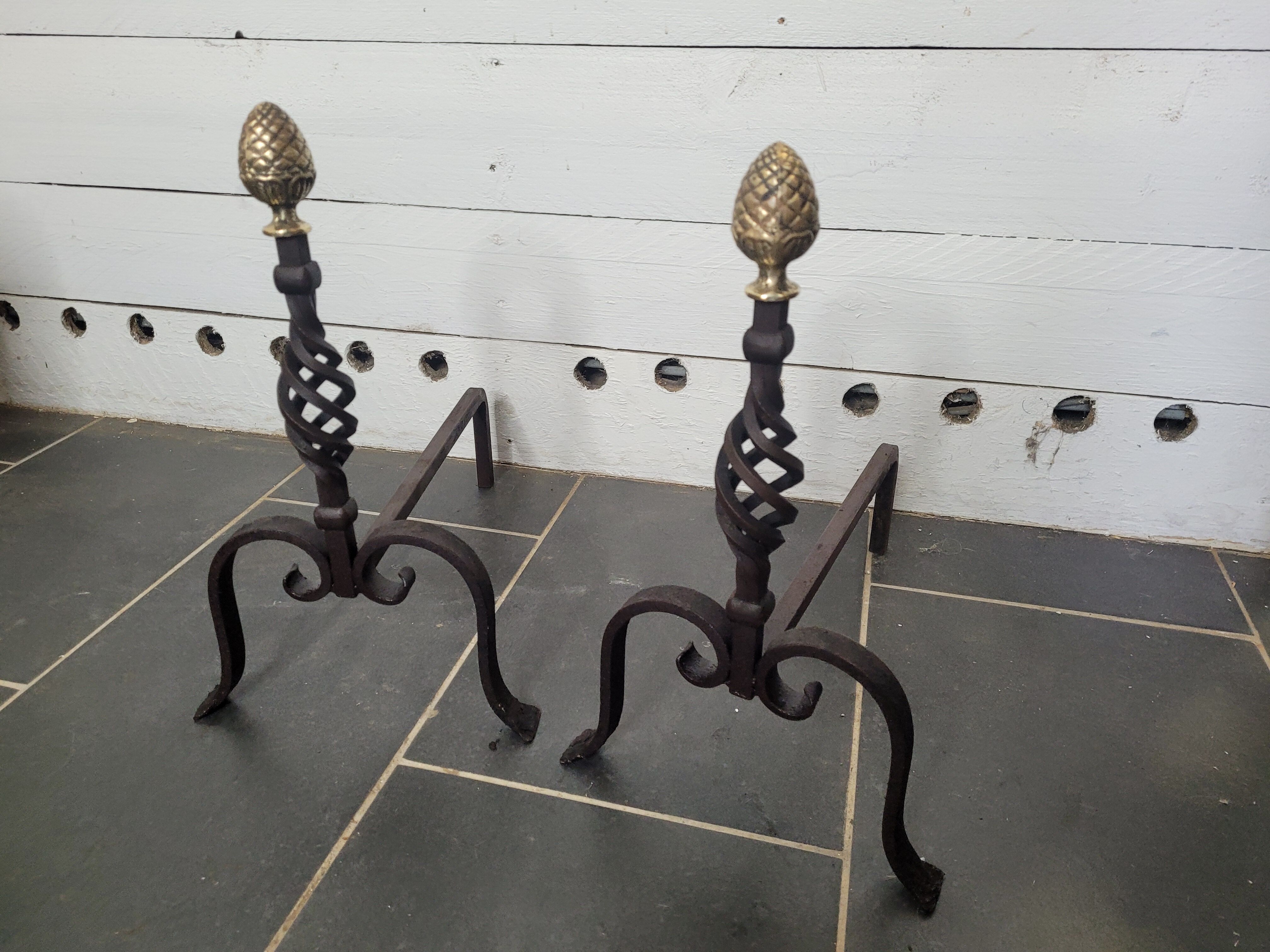 Old pair of wrought iron pegs with brass pine cone