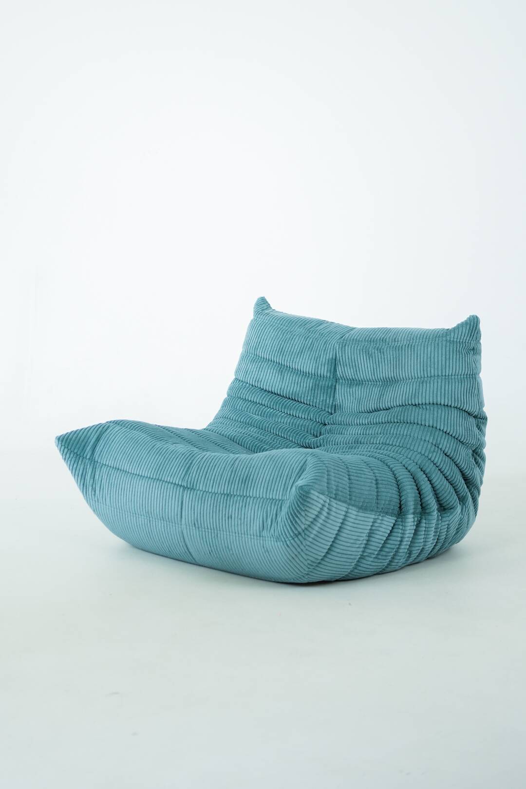 Ensemble de fauteuil et pouf Togo en velours côtelé bleu clair.