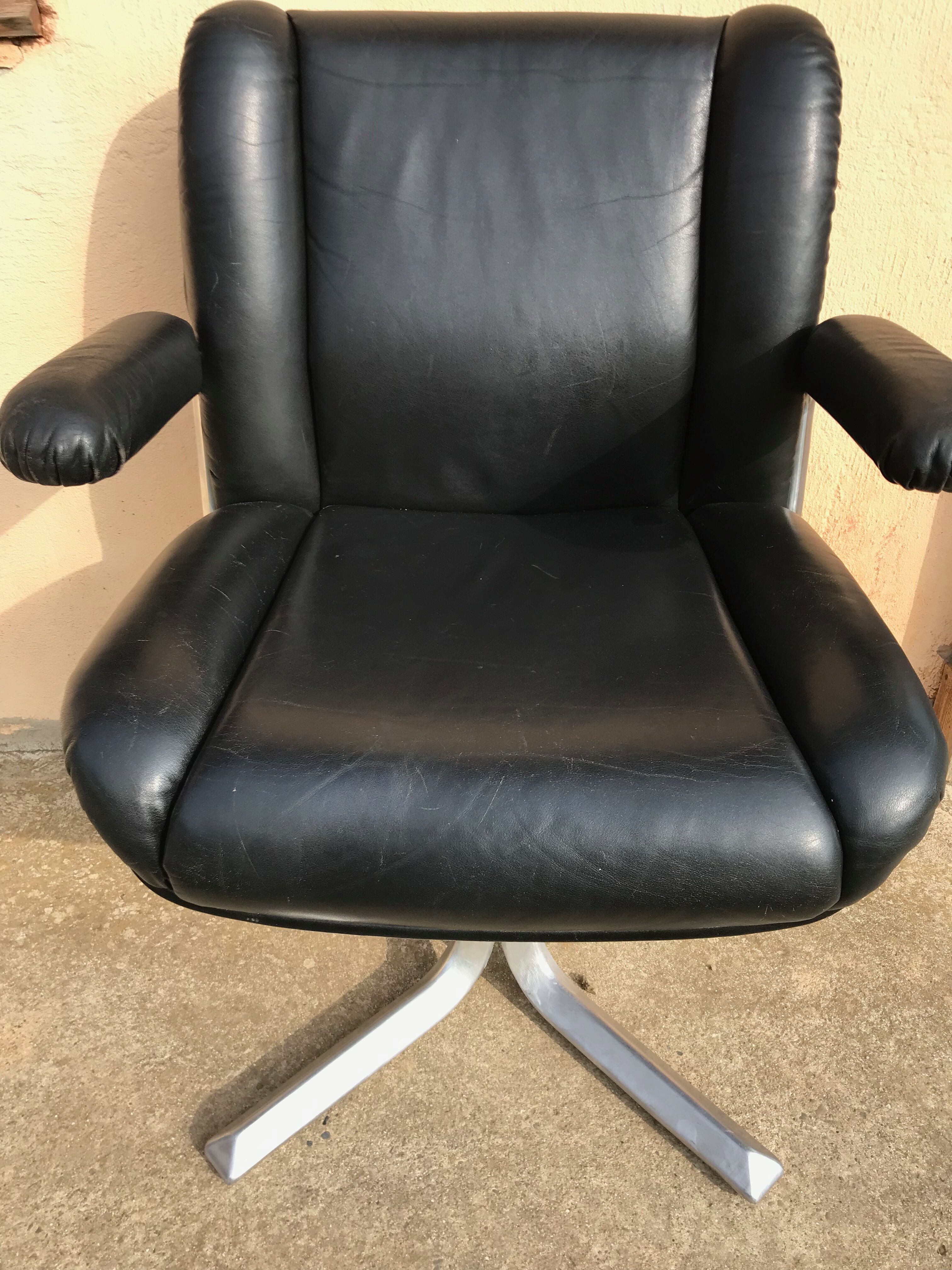 Vintage swivel black leather armchair