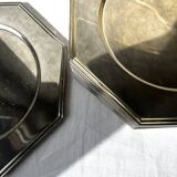 Many octagonal presentation plates in silver-plated metal.