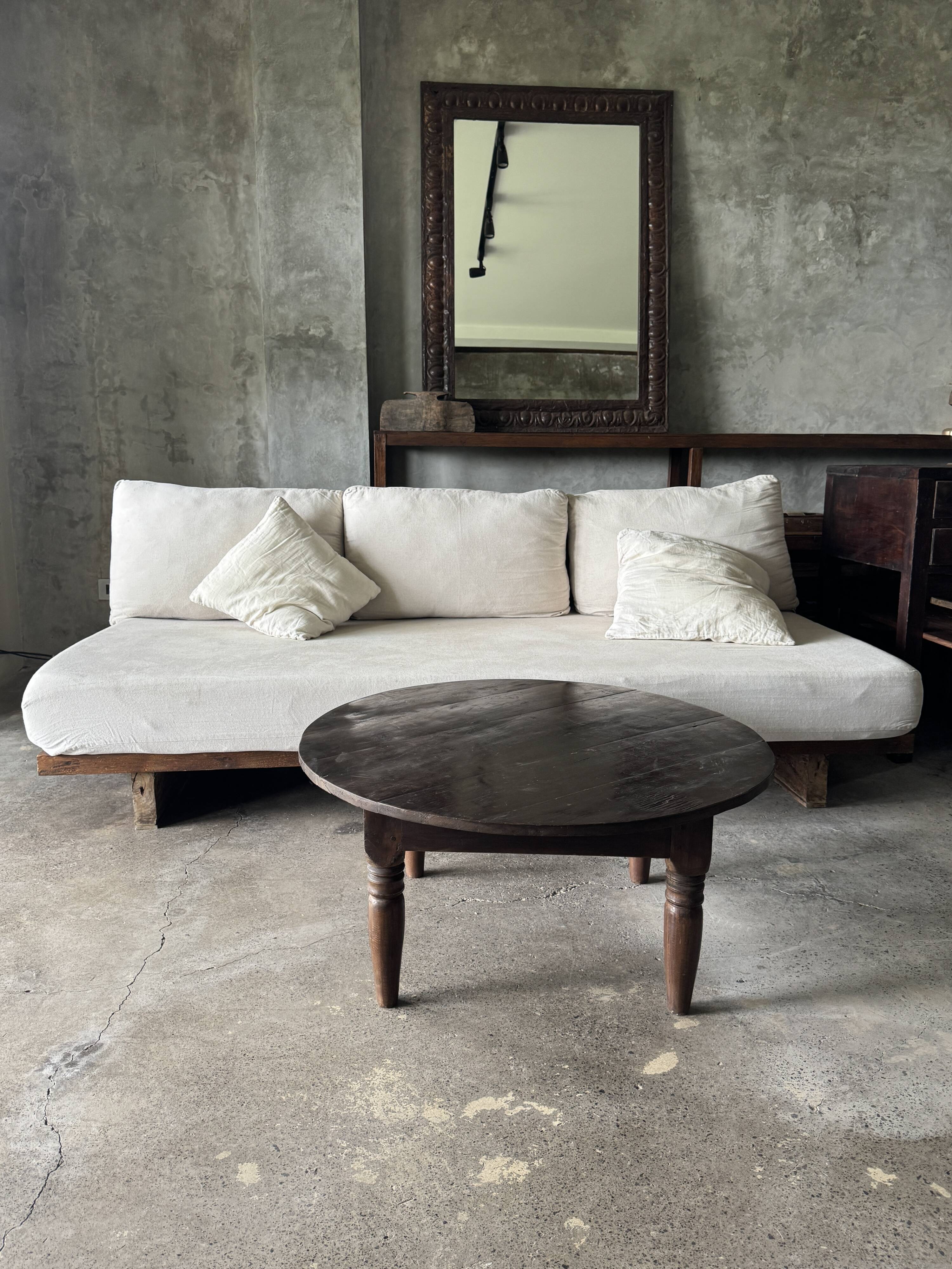 Coffee table, round antique Indonesian teak table with straight legs.