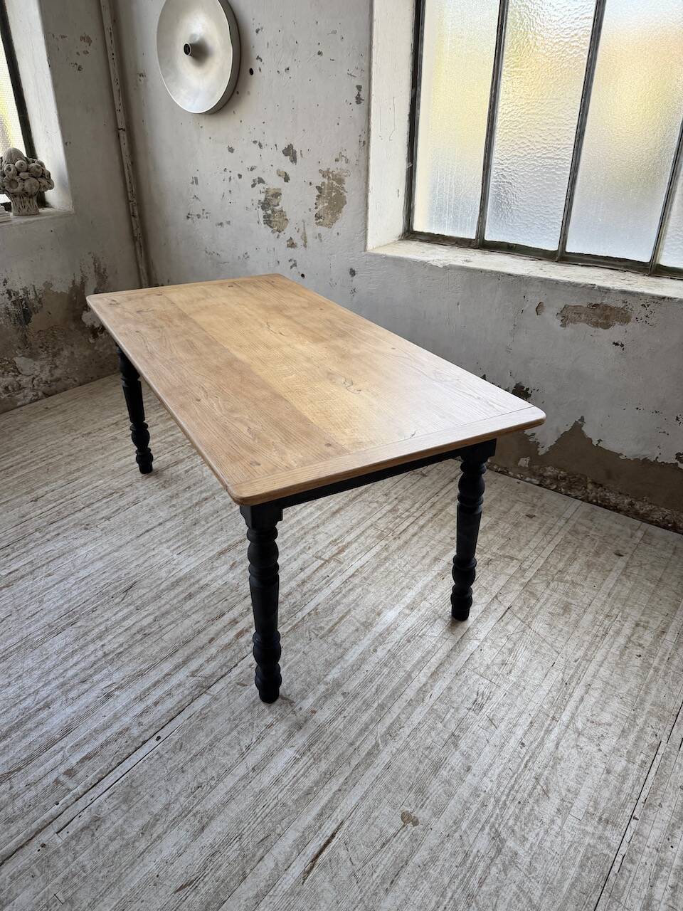 Oak farmhouse table with turned black legs.