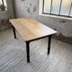 Oak farmhouse table with turned black legs.