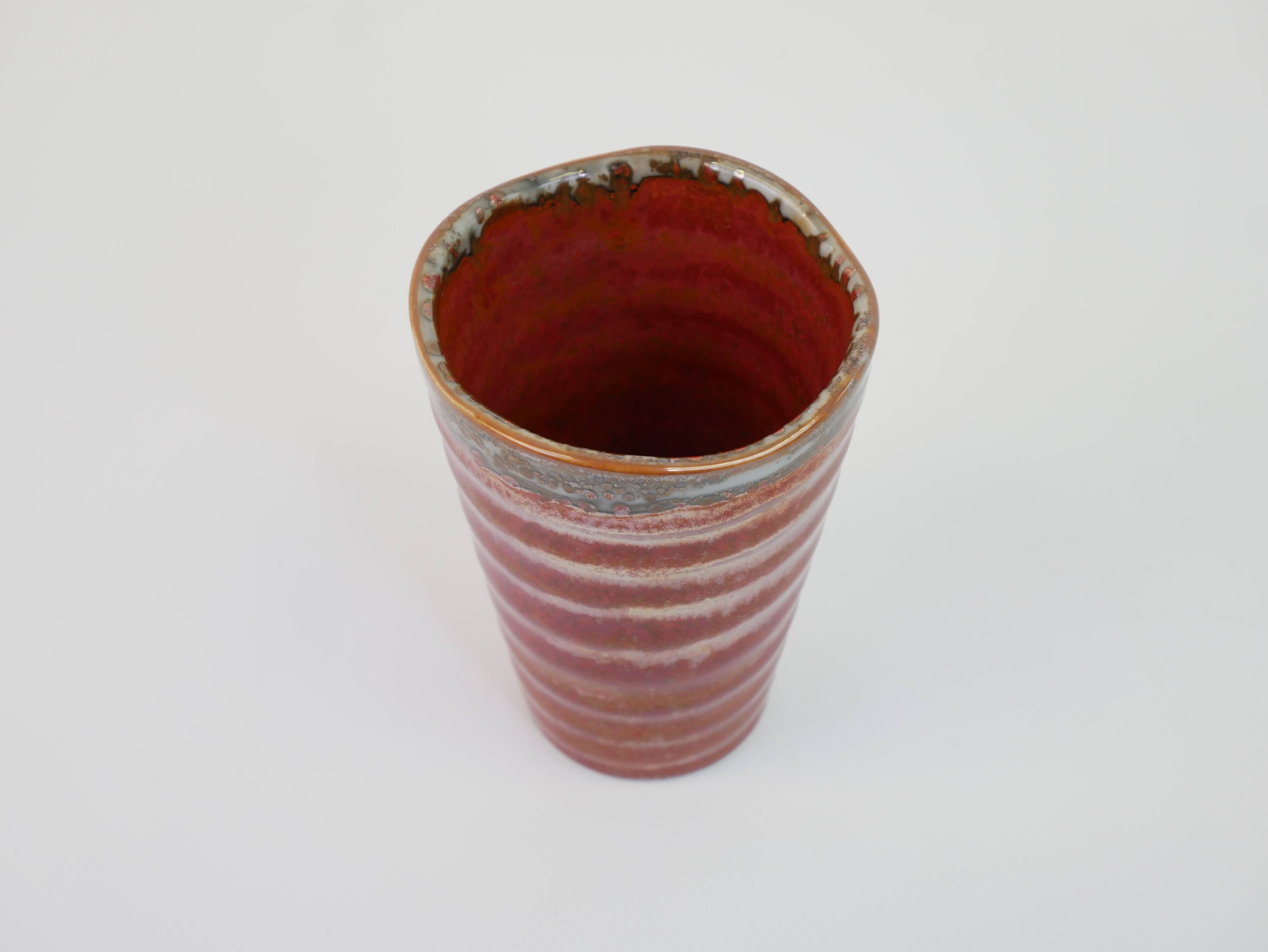 Small orange glazed ceramic cup