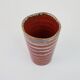 Small orange glazed ceramic cup