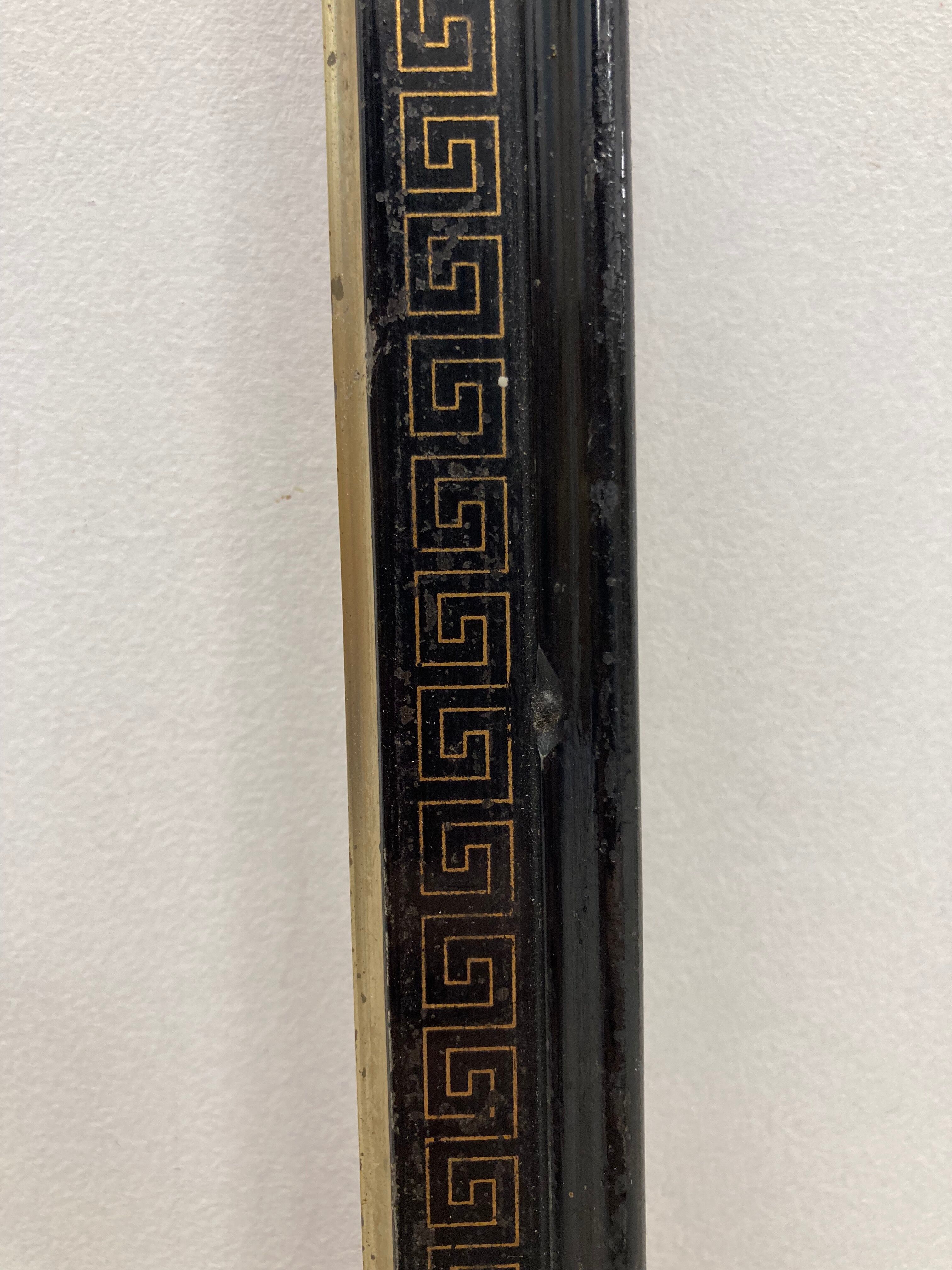 Black and gold frame decorated with Greek frieze decoration