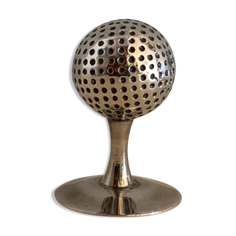 Silver metal paper press, golf ball on tee