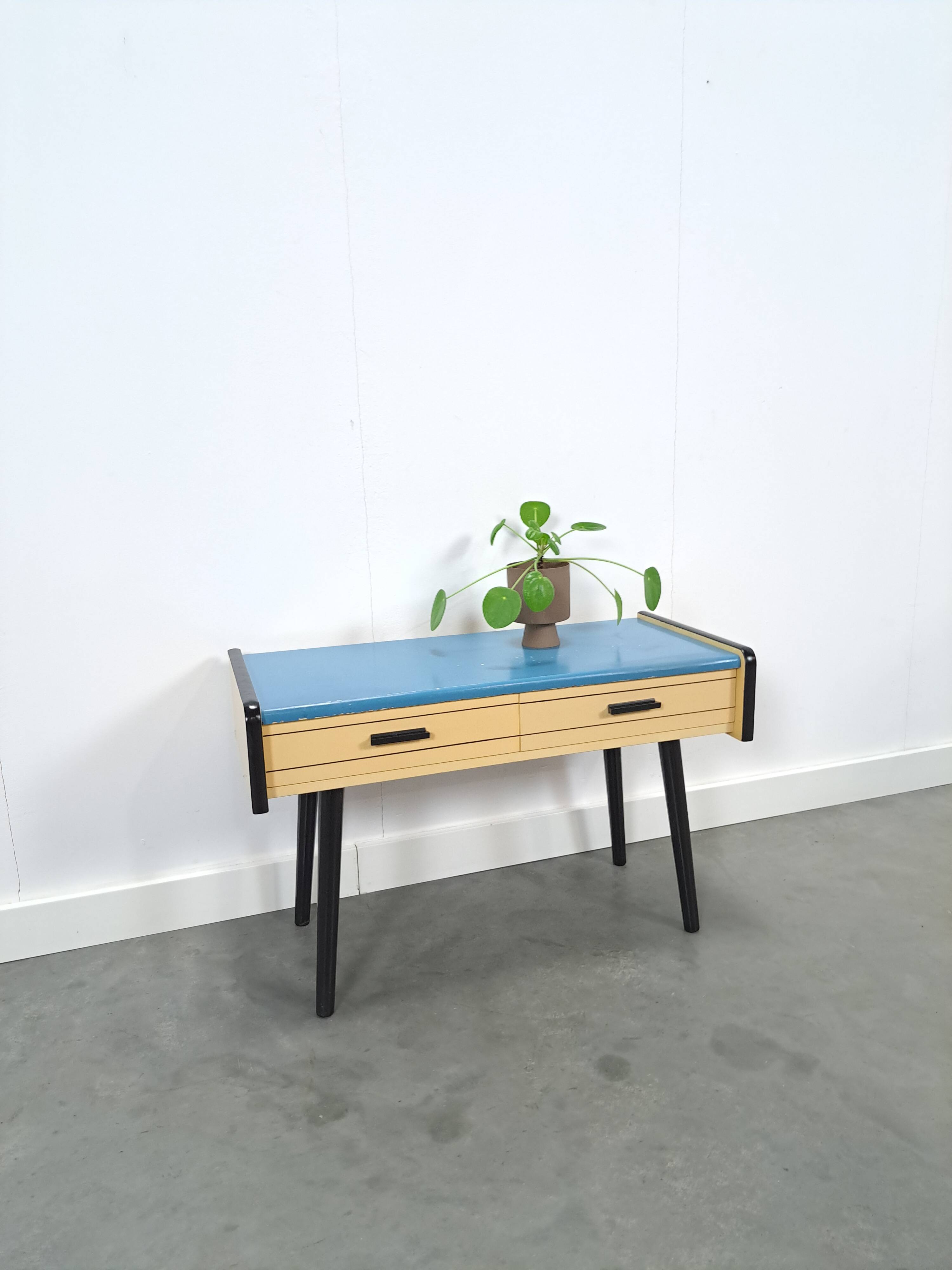 Jaren 50 ladekastje met blauw blad en zwarte poten