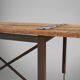 Table d'appoint industrielle avec cadre en métal et plateau en bois et plateforme amovible.