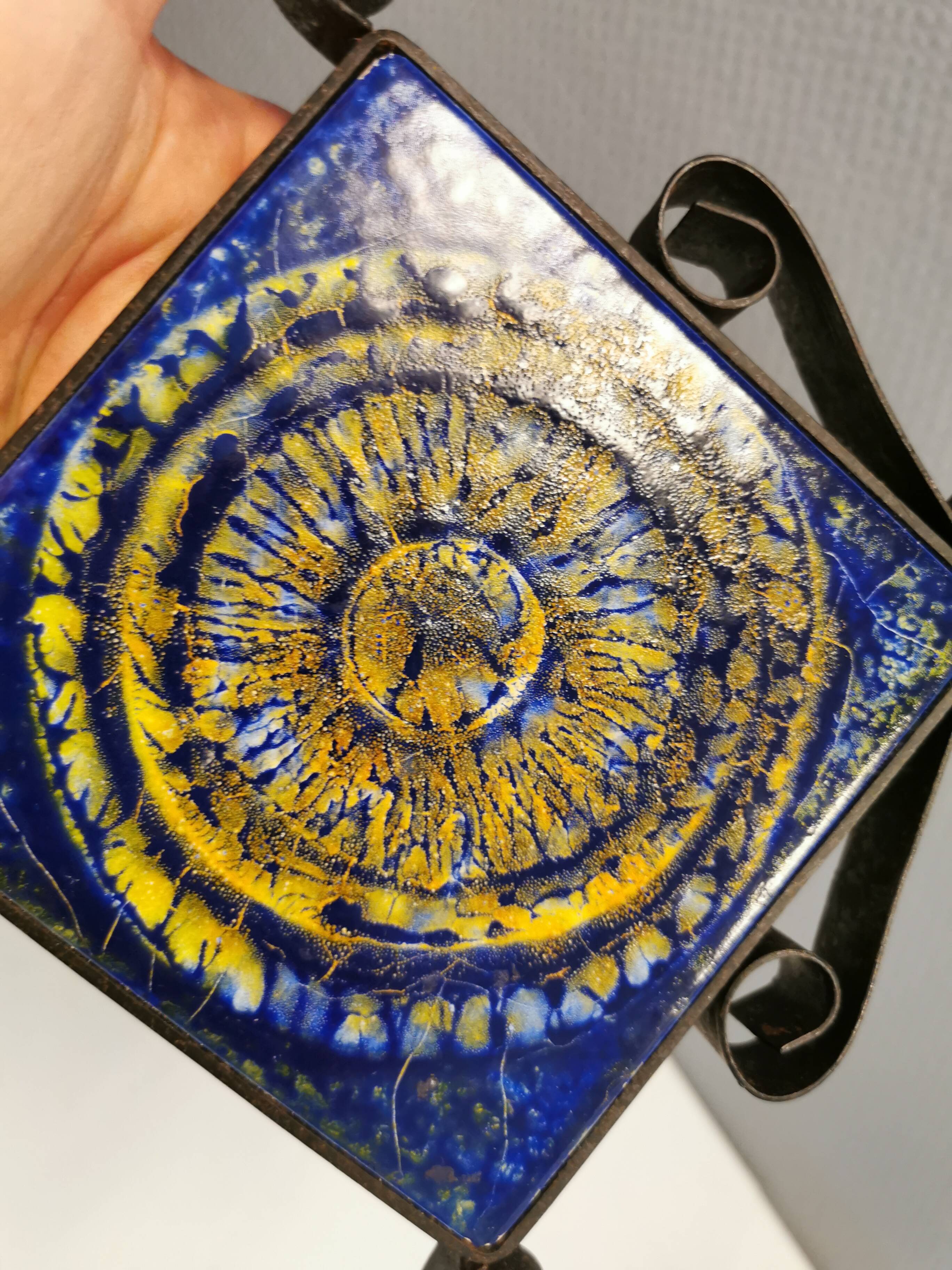 Wall-mounted candle holder in cast iron and ceramic. Estimated Danish and from the 70s.