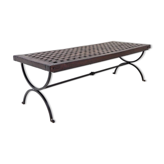 Solid wood coffee table with an openwork design and wrought iron legs.