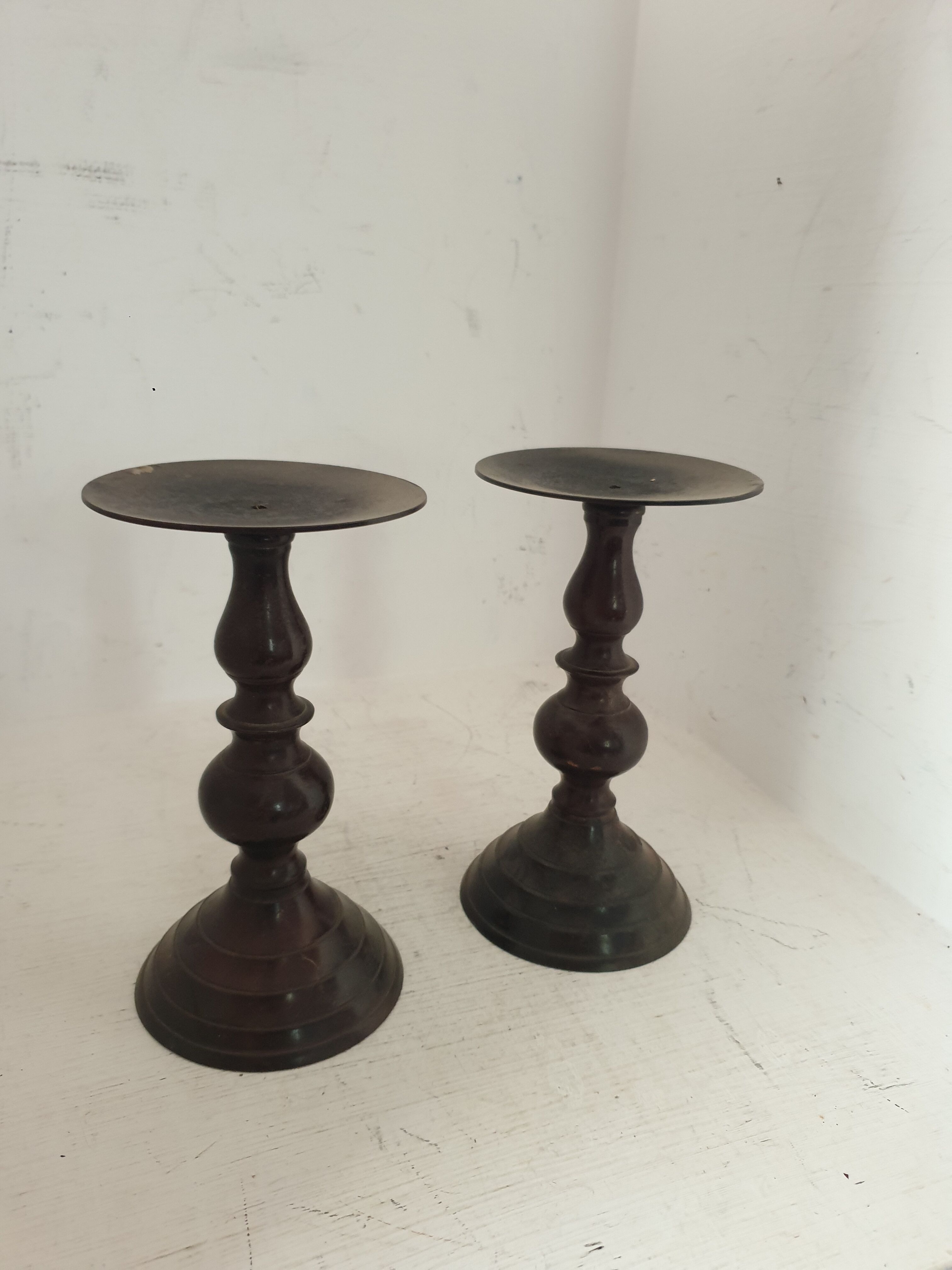 Two pairs of patinated brass candle holders