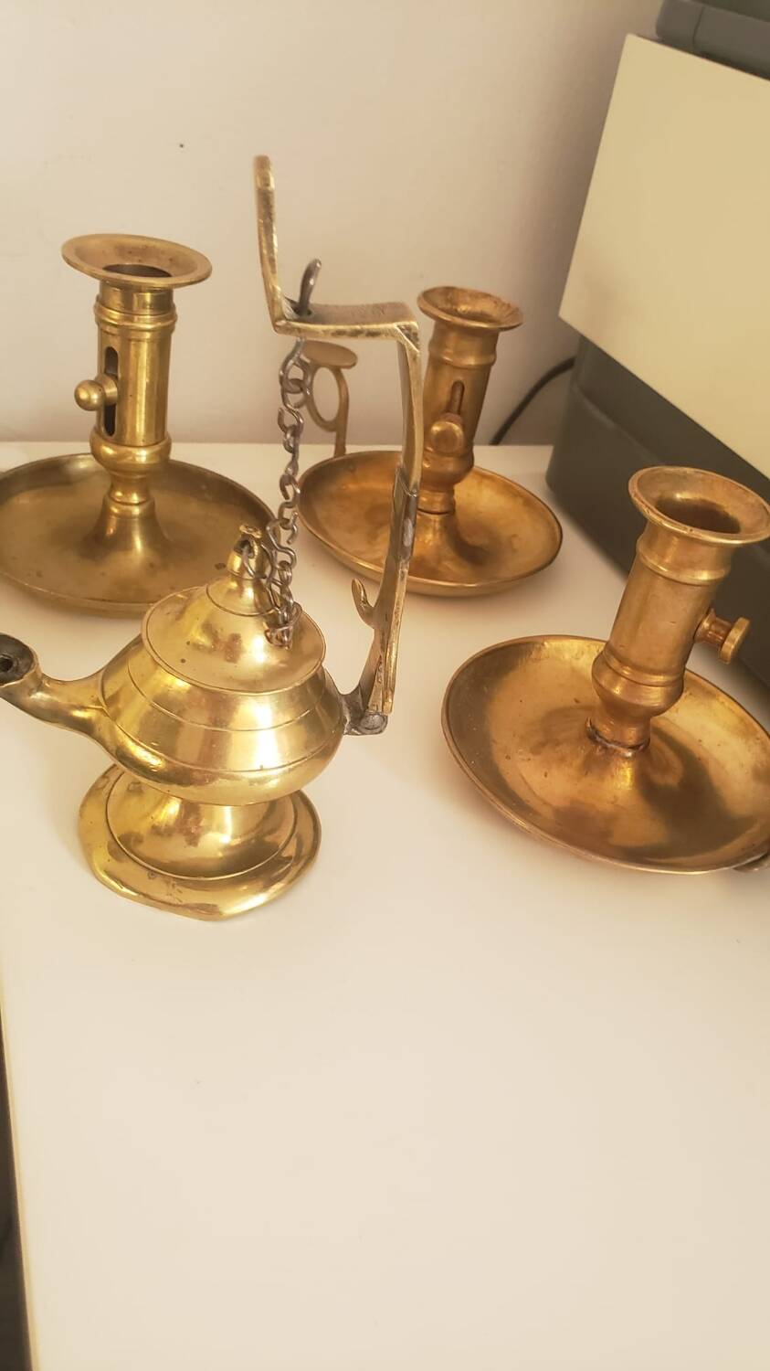 Many candlesticks and a small oil lamp.