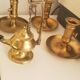 Many candlesticks and a small oil lamp.