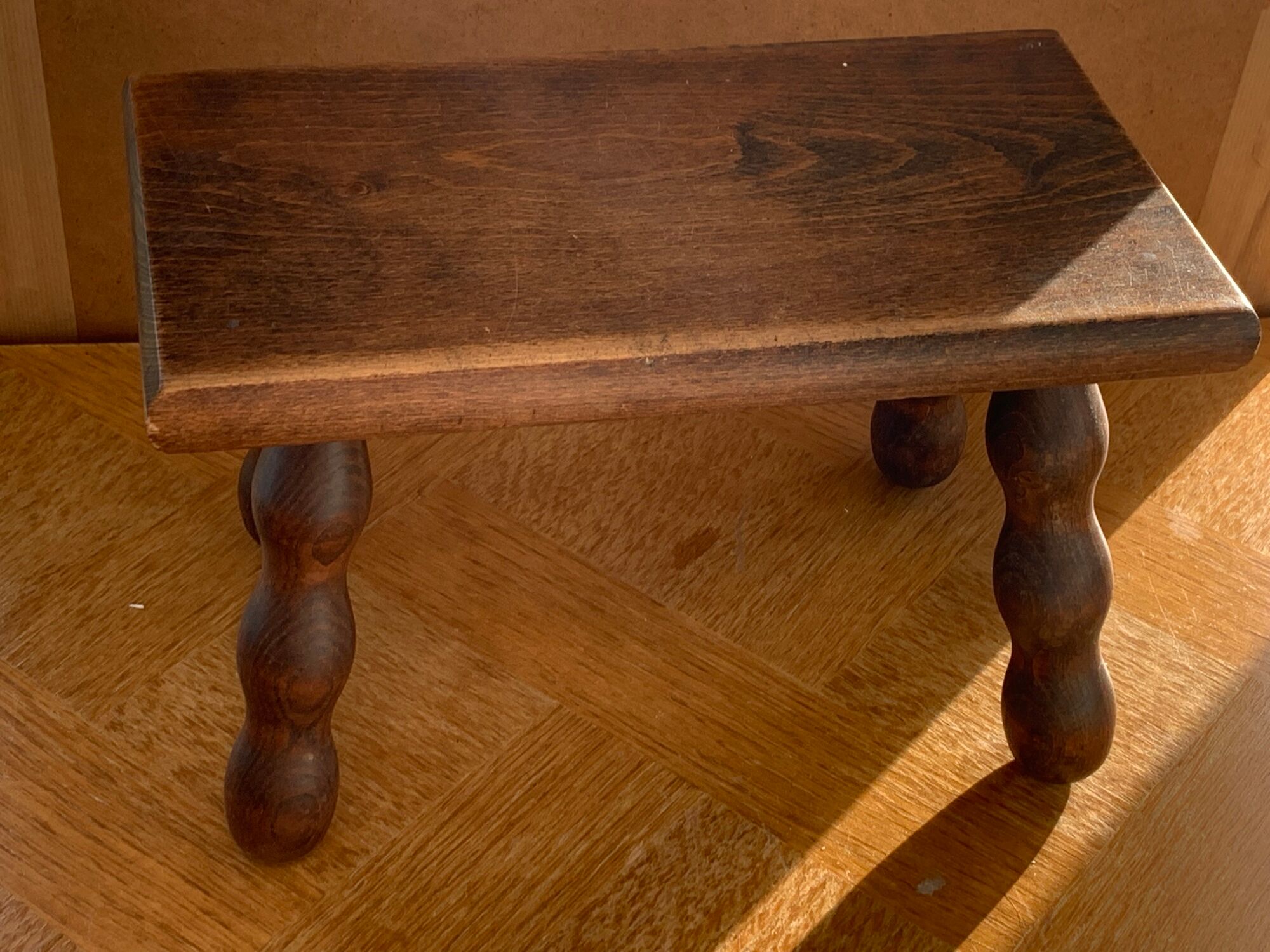 Footstool in varnished wood turns old