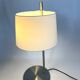 Large brushed metal table lamp with an ecru shade.