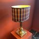 Lamp base in gilded brass, oval silk lampshade with a checkered pattern in burgundy.