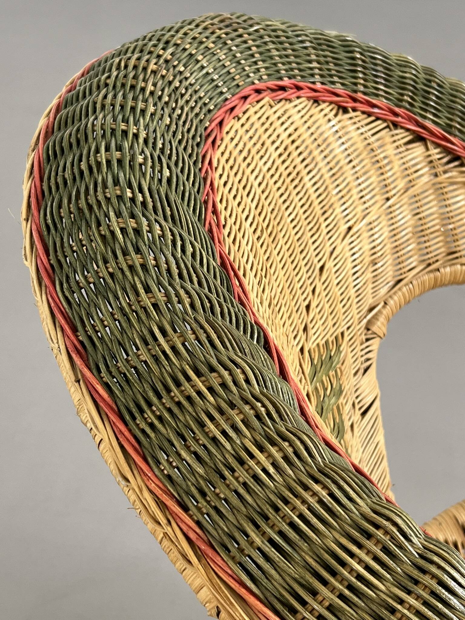 Cabriolet style armchair in rattan, wicker and green and red edging