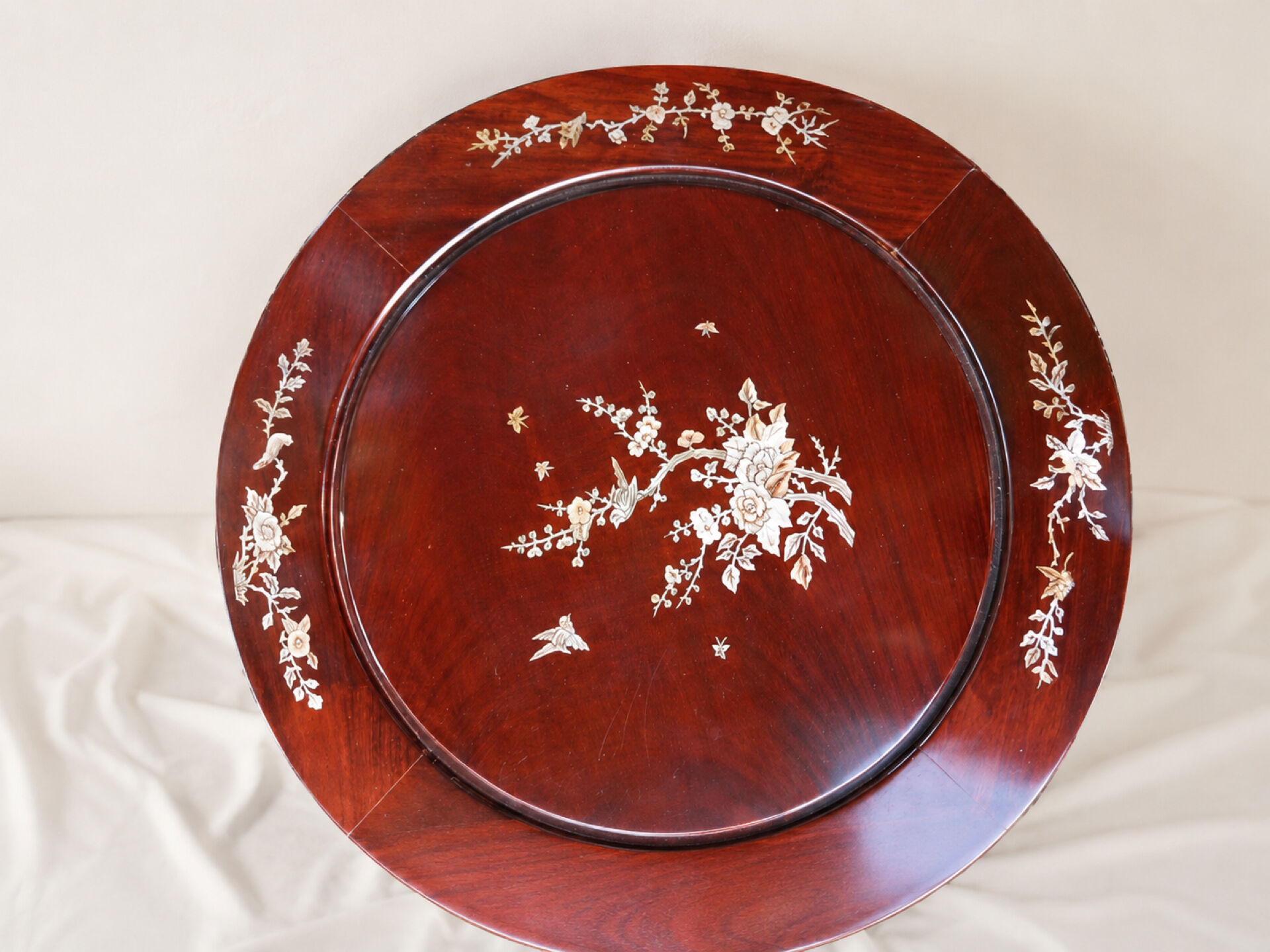 Mahogany gueridon with mother-of-pearl inlays featuring Asian floral decor.