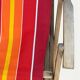 Vintage deck chair with red and orange striped fabric, original patina.