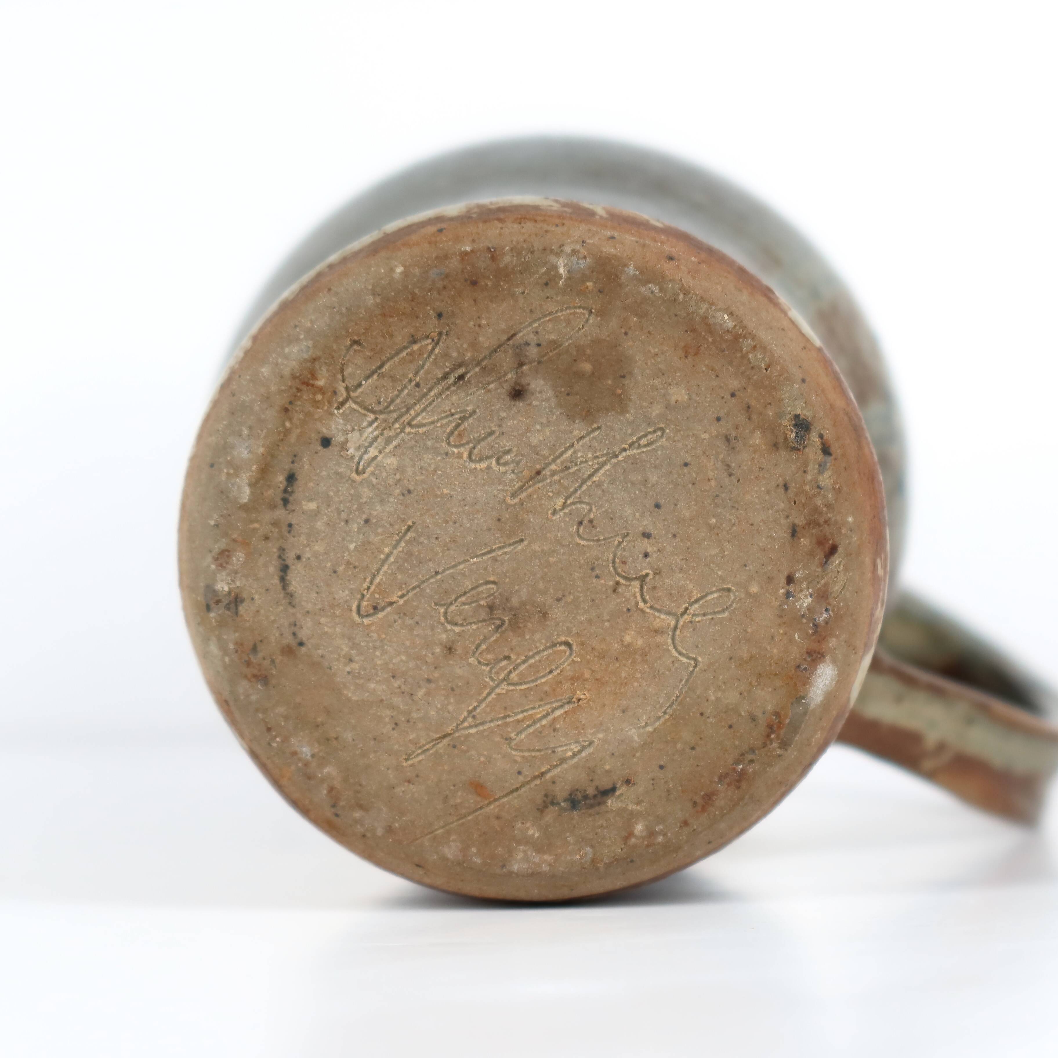 Handcrafted stoneware pitcher with blue-green hues, signed piece