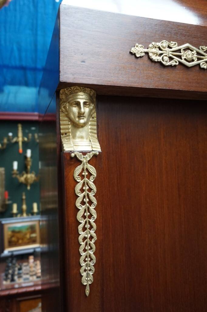 Empire style mahogany display bookcase with gilt bronze decoration and three doors.