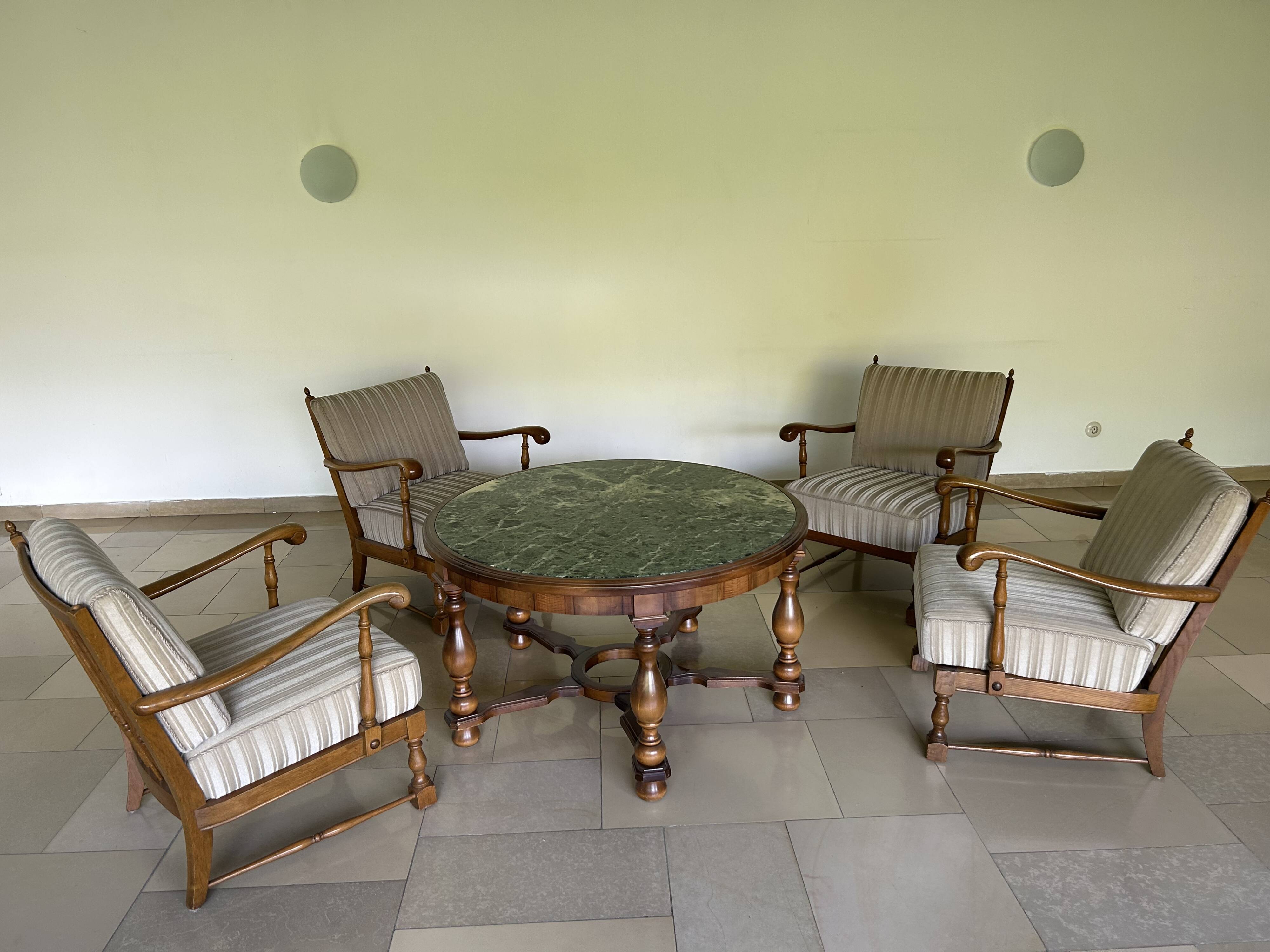 Ensemble de salon vintage avec table basse en marbre vert et quatre fauteuils.