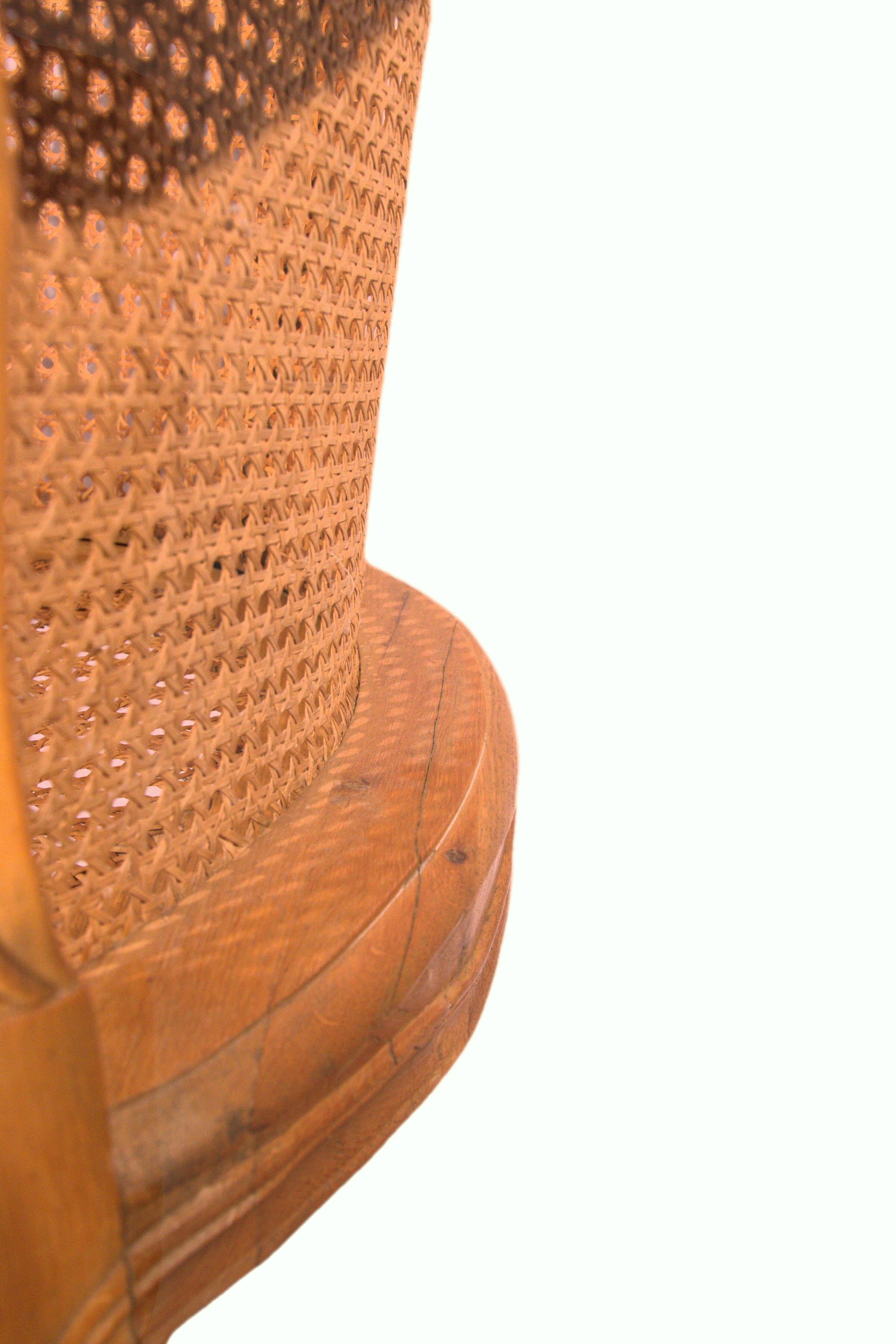 Armchair in solid oak with caning and a central leg (known as couillard), 89x68cm.