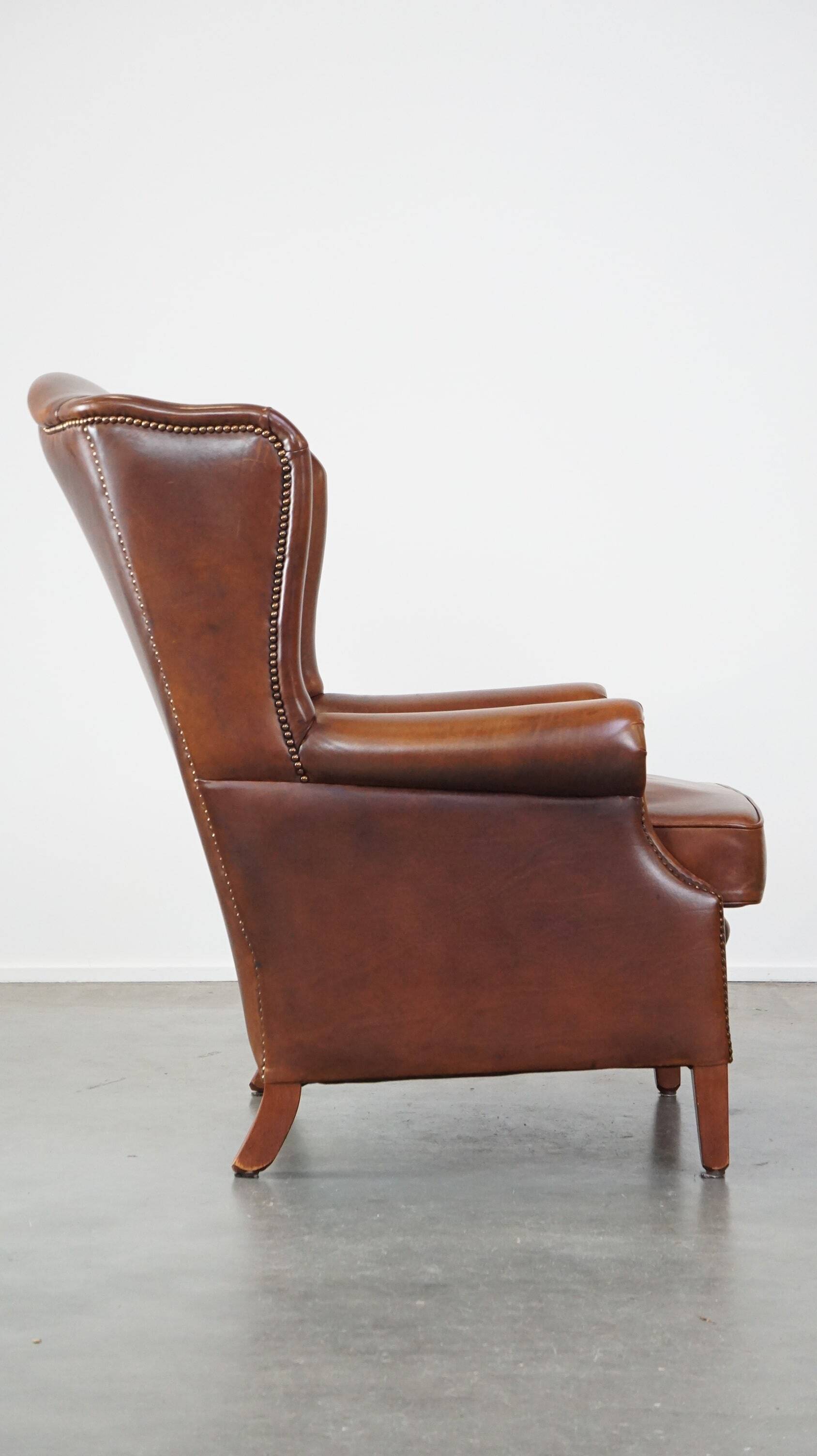 Fauteuil à oreilles en cuir de vachette cognac