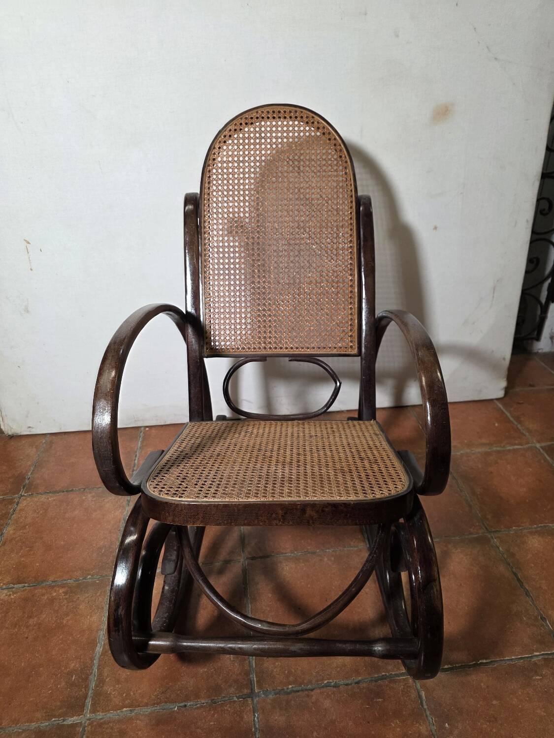 Curved wooden rocking chair with caning