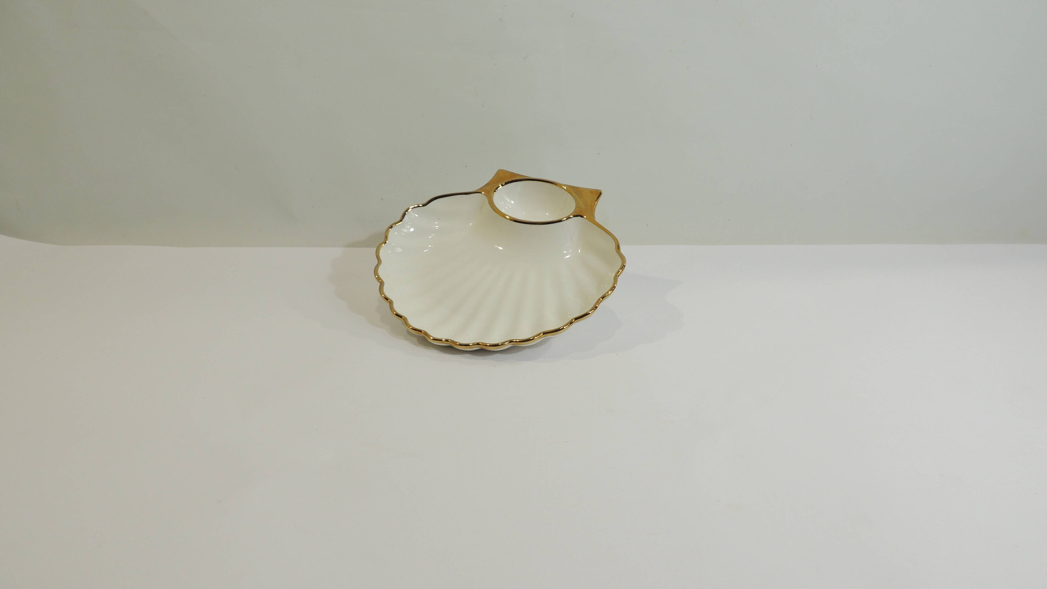 Shell-shaped porcelain pocket bowl from Queen’s Porcelain, with a gold rim.