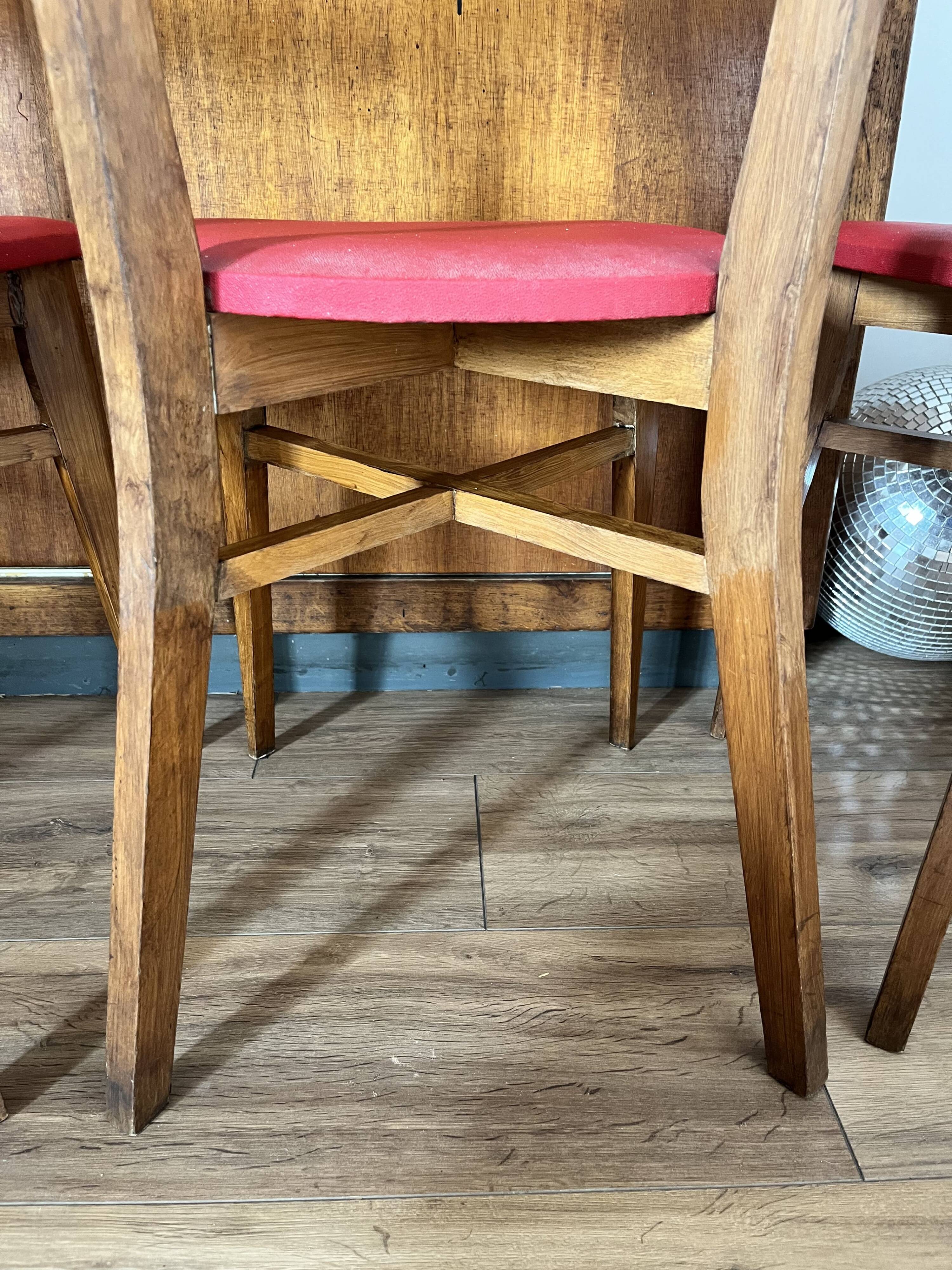 Set of 4 wooden chairs with red vinyl.