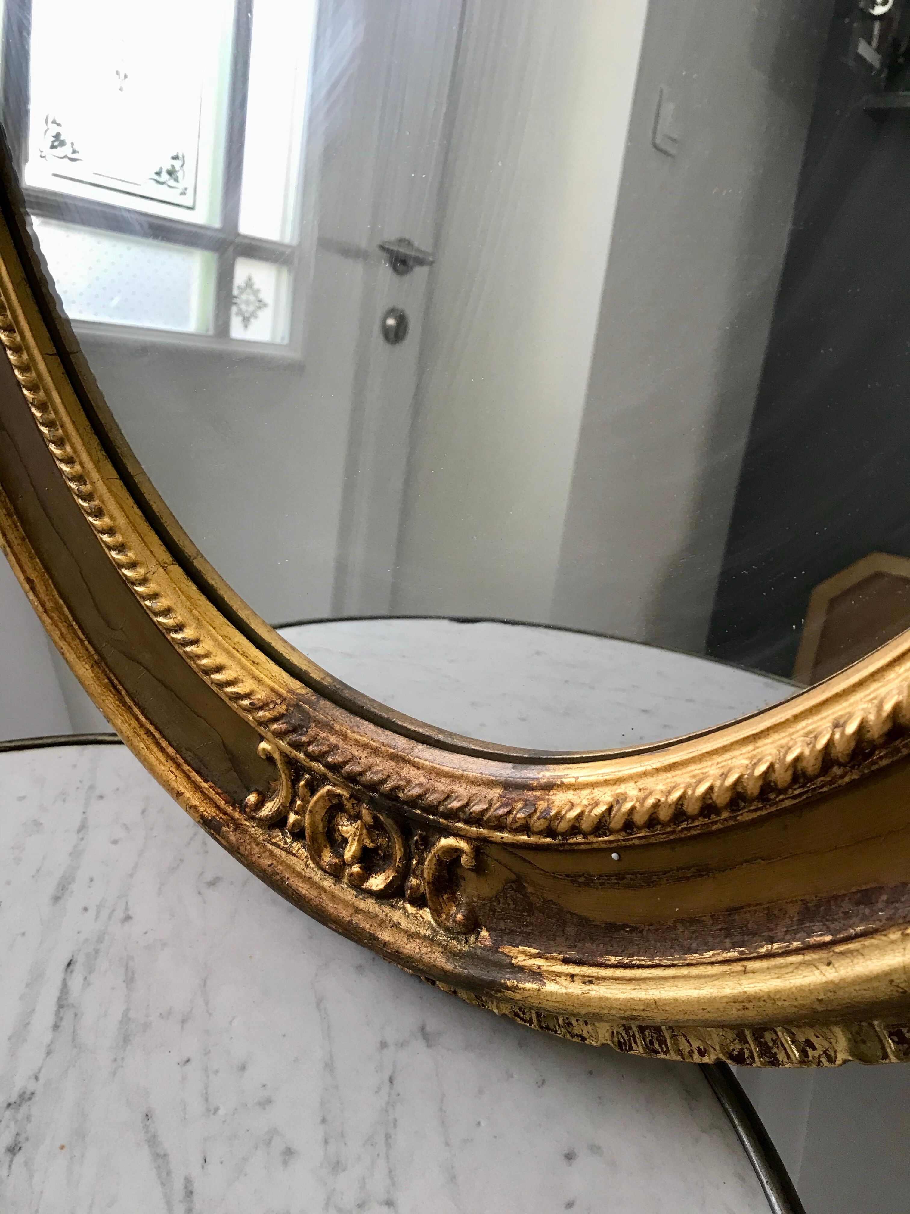 Grand miroir oval en stuc doré vintage